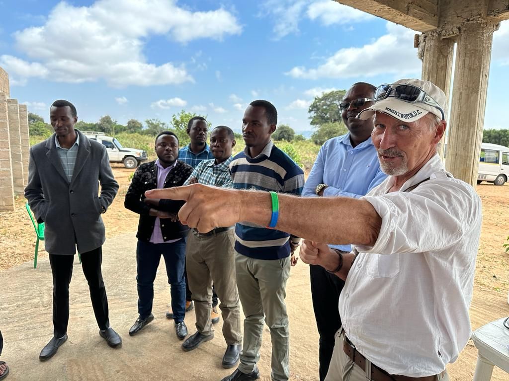 Community leaders and a visiting volunteer walking a building site together